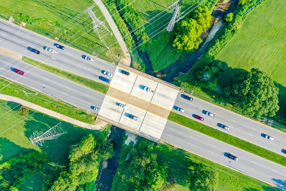 aerial view bridge creek powerlines with cars road copy